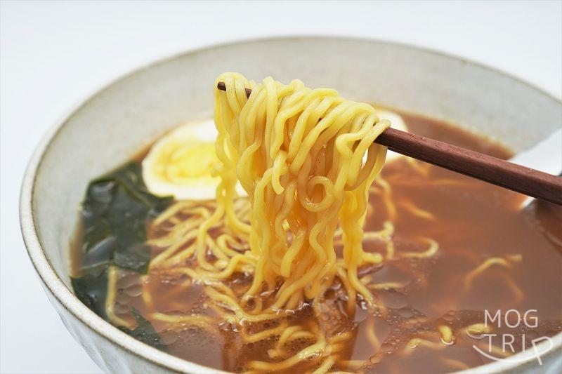 ラーメン 旭川特一番 濃旨旭川醤油味　麺をお箸で持ち上げた様子