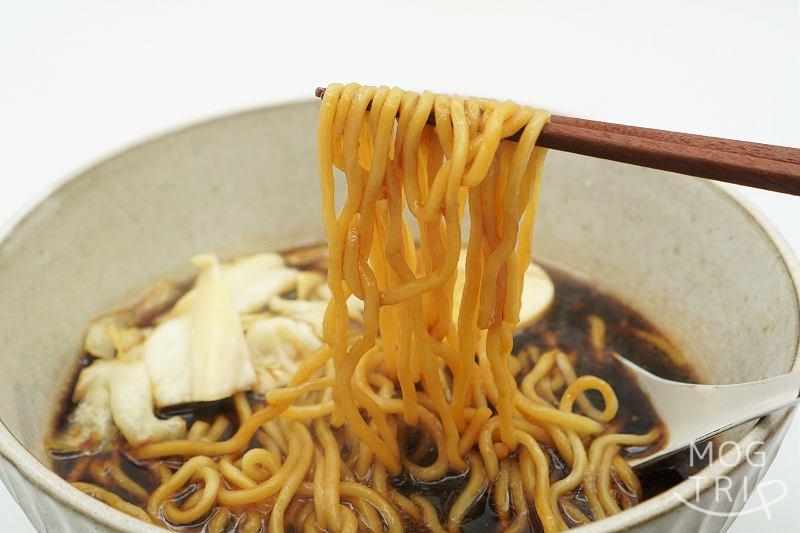 生ラーメンすすきのブラック｜いそのかづお　箸で麺を持ち上げた様子