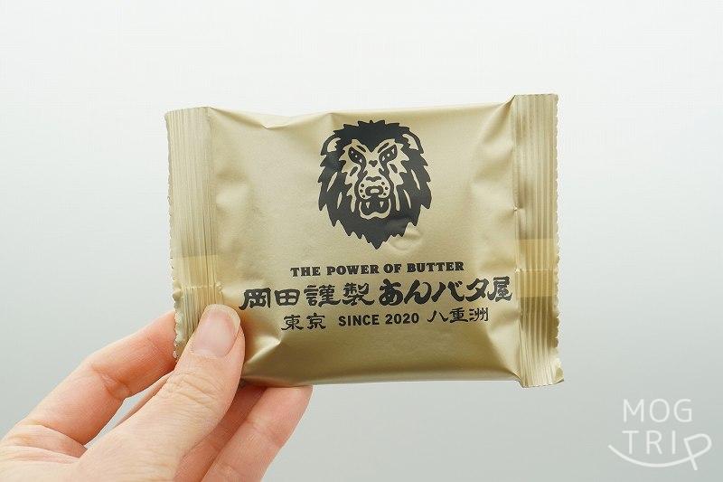 東京駅限定品 岡田謹製あんバタ屋の「あんバタフィナンシェ」の個包装を手に持っている様子