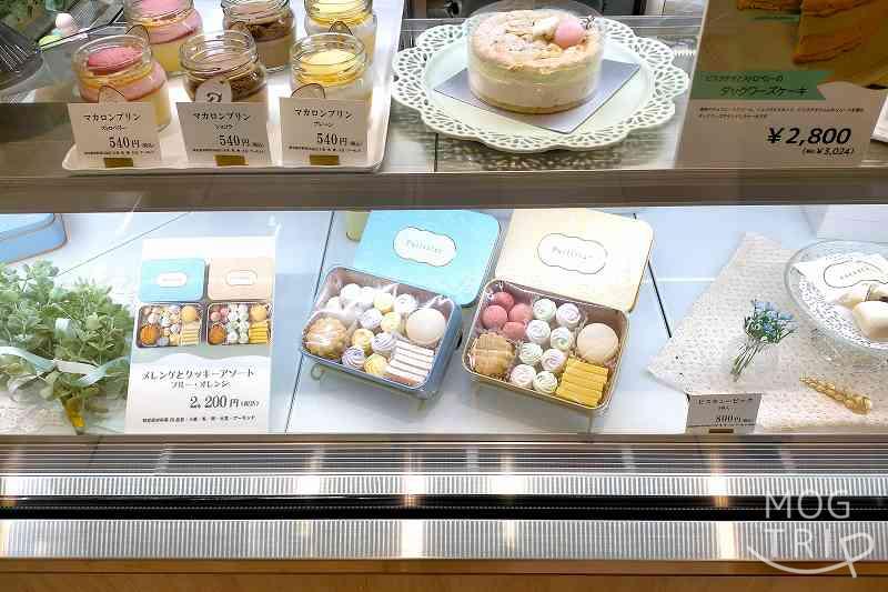 「Petitrier EXITMELSA店」の店先にあるガラスケースの中にクッキー缶が並べられている