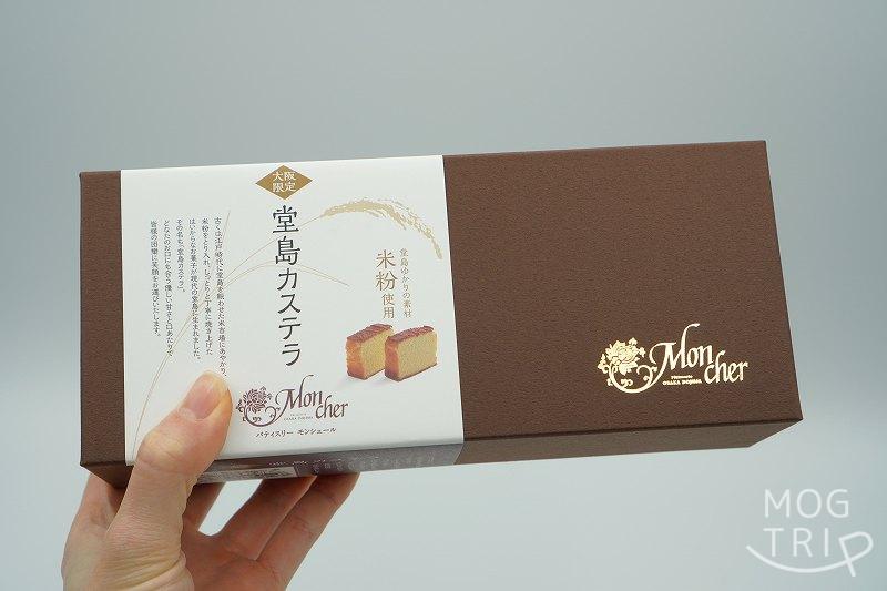 【大阪限定品】パティスリーモンシェールの堂島カステラの箱を手に持っている様子