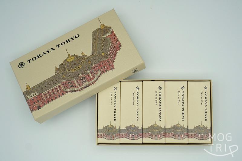 東京駅にある「とらやグランスタ東京店」と「TORAYA TOKYO」の限定品、小形羊羹 夜の梅® 5個入の箱が、ふたを開けた状態でテーブルに置かれている