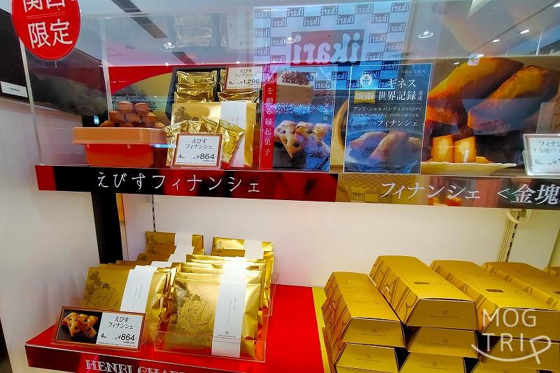 【関西限定品】アンリ・シャルパンティエのえびすフィナンシェが赤と金色の棚の上に並べられている