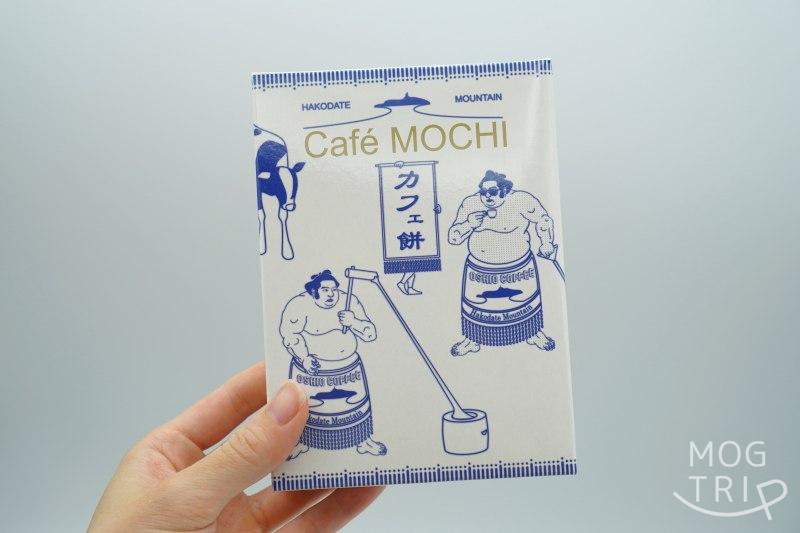 ハコダテマウンテンコーヒー×天狗堂宝船の「カフェ餅」の箱を手に持っている様子